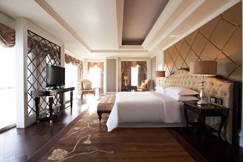 1 dormitorio con 1 cama blanca y TV en Four Points by Sheraton Langfang, Gu'an, en Gu'an