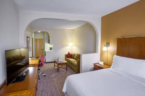 una camera d'albergo con letto e divano di Four Points by Sheraton Charlotte/Pineville a Charlotte