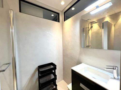 une salle de bain avec un lavabo et un miroir dans l'établissement APPARTEMENT MODERNE ET SPACIEUX AU COEUR DE BIARRITZ 6 pers, à Biarritz