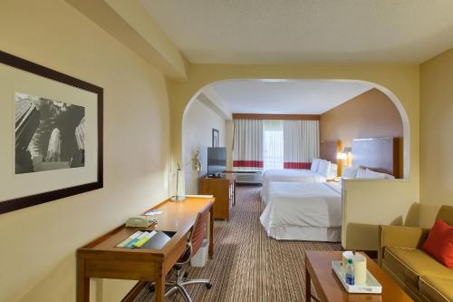 a hotel room with a bed and a couch at Four Points by Sheraton Charlotte/Pineville in Charlotte