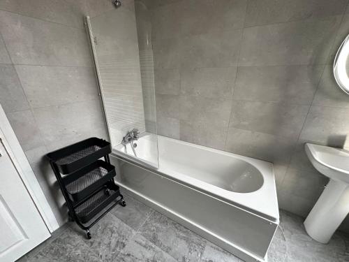 a bathroom with a bath tub and a sink at Bex Stays 2 Bed Property in Leeds
