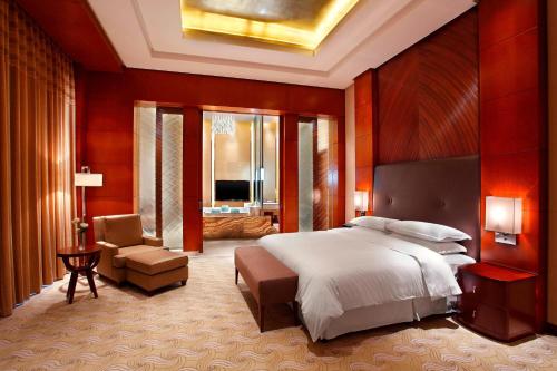 錦州的住宿－錦州喜來登酒店，一间带大床的卧室和一间客厅