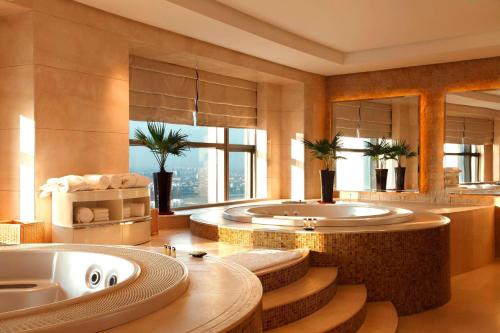 a bathroom with a tub and a large window at Sheraton Jinzhou Hotel in Jinzhou