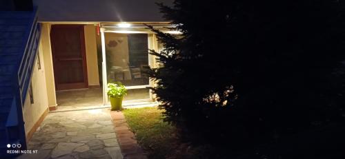 a door to a house at night with a potted plant at Elaiones house in Thessaloniki