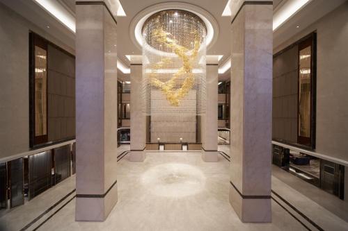 a lobby with a chandelier in a building at Sheraton Grand Zhengzhou Hotel in Zhengzhou