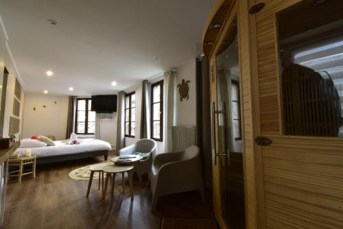 une chambre avec un lit, une table et des chaises dans l'établissement Appartement jacuzzi privatif Love&Zen, à Verneuil-sur-Avre