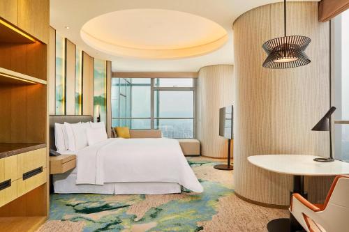 温州市にあるThe Westin Wenzhouのベッドとテーブルが備わるホテルルームです。