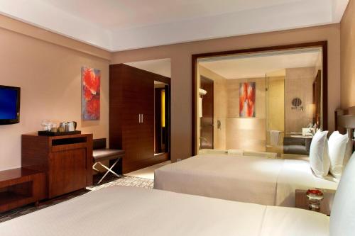 um quarto de hotel com uma cama e um espelho em Four Points by Sheraton Taicang em Taicang