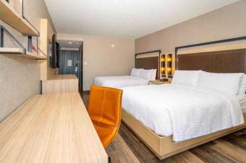 a hotel room with two beds and a television at Four Points by Sheraton Salt Lake City Airport in Salt Lake City
