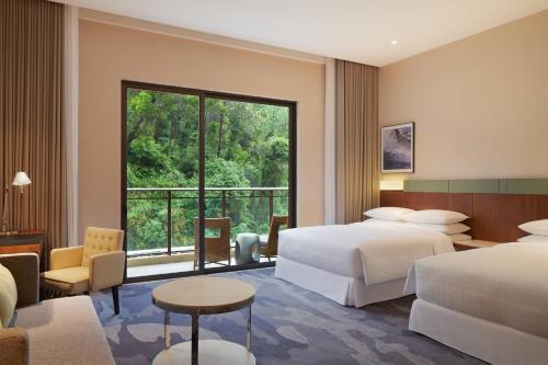 a hotel room with two beds and a large window at Four Points by Sheraton Guangdong, Heshan in Heshan
