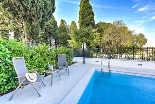 a patio with two chairs and a swimming pool at Villa Danica ZadarVillas in Sukošan