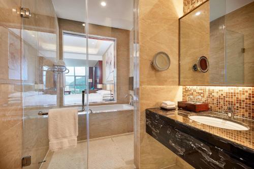 uma casa de banho com uma cabina de duche em vidro e um lavatório. em Four Points by Sheraton Liupanshui em Shuicheng
