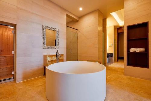 a bathroom with a large white tub in a room at Four Points by Sheraton Liupanshui in Shuicheng