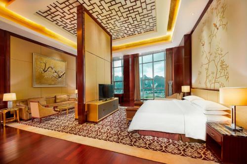 a bedroom with a bed and a living room at Four Points by Sheraton Liupanshui in Shuicheng