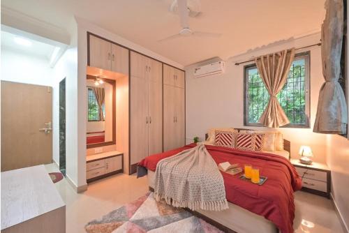 a bedroom with a red bed and a bathroom at Lifeline Villas - The Secret Place Lonavala With Huge Pool And Lawn Area in Lonavala