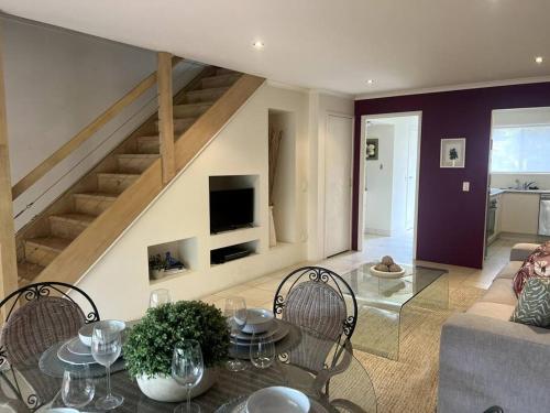 a living room with a table and chairs and a staircase at A touch of lux in the Redlands! in Capalaba