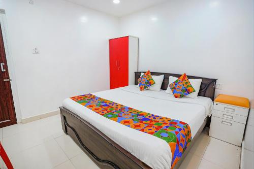 a bedroom with a large bed with colorful sheets at FabExpress Lloyds Inn I - Nr Korea Embassy, Royapettah in Chennai