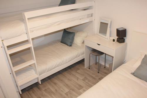 a bedroom with a bunk bed and a desk at Hunny Hideaway, Hunstanton - dog friendly haven by the sea in Hunstanton