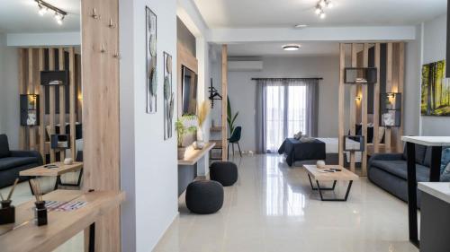 a living room with a blue couch and tables at ALBA SUITE APARTMENT in Kalabaka