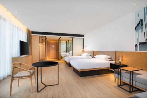 pokój hotelowy z 2 łóżkami i stołem w obiekcie Fairfield by Marriott Taiyuan South w mieście Taiyuan
