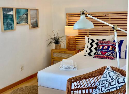 a bedroom with a white bed and a lamp at Casa Azul in Nazaré