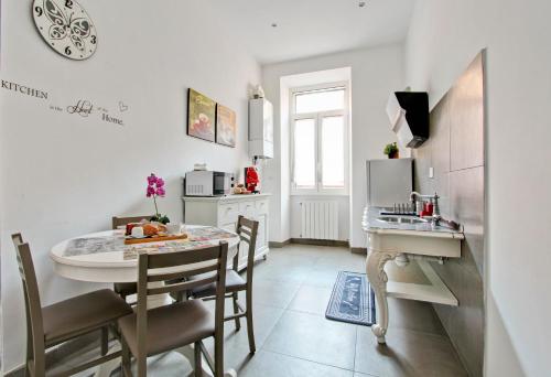 a kitchen and dining room with a table and a sink at Domvs Romae Apartment in Rome