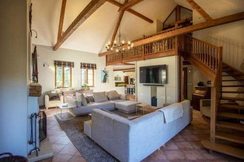 a large living room with a couch and a staircase at 7 Bedroom Secluded Villa close to Prague in Ricany