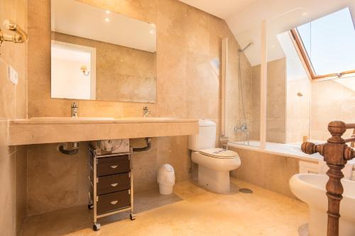 a bathroom with a sink and a toilet and a mirror at 2233-Lovely 2 bedrooms on the beach, pool and port in Manilva