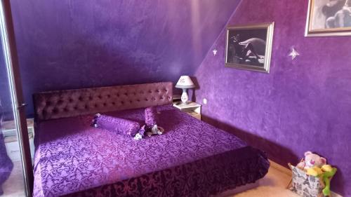 a purple bedroom with a bed with purple walls at Апартамент-Надин in Krumovgrad