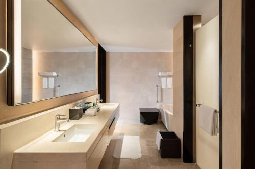 a bathroom with a sink and a mirror and a tub at Four Points by Sheraton Chengdu, Anren in Dayi