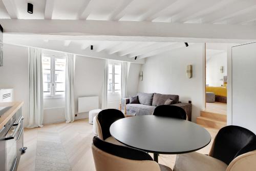 un salon avec une table et des chaises dans l'établissement Pick A Flat's Apartement in Saint-Germain-des-Prés - Rue de Seine, à Paris