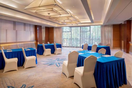 a conference room with blue tables and white chairs at Sheraton Changchun Jingyuetan Hotel in Changchun
