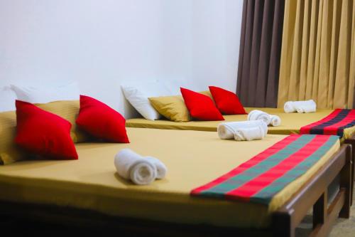 Duas camas individuais com almofadas vermelhas e azuis. em Royal Hub em Negombo