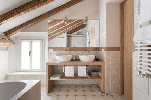 a bathroom with two sinks and a mirror at Relais Roncolo 1888 in Quattro Castella