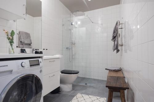 a white bathroom with a washer and a toilet at Slottsholmen Hotell och Restaurang in Västervik