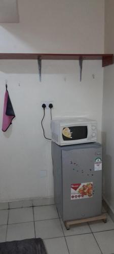 a kitchen with a microwave on top of a refrigerator at Georgia Furnished Apartments in Machakos