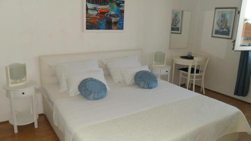 a bedroom with a white bed with blue pillows at Apartments Aba in Hvar