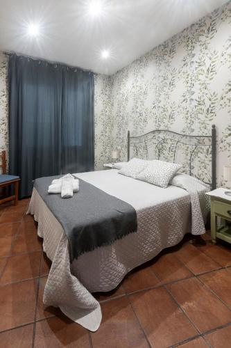 a bedroom with a bed in a room with wallpaper at Apartamentos turísticos La Flor in Muros de Nalón