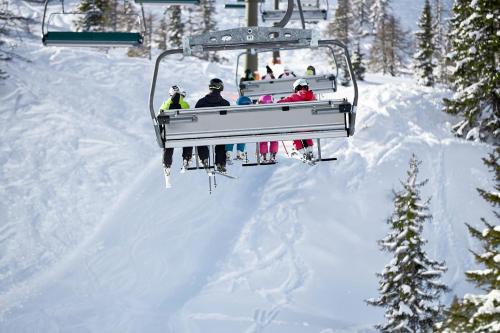 a group of people riding a ski lift in the snow at ROBINSON AMADÉ in Kleinarl