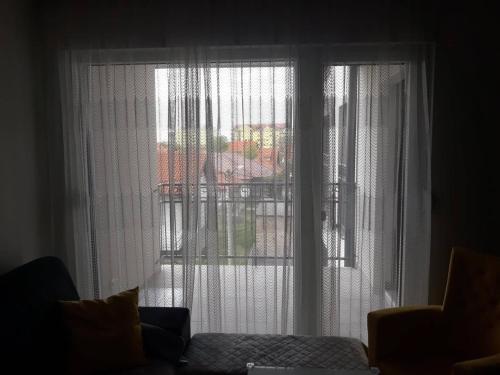 een raam met witte gordijnen in de woonkamer bij Apartman See in Bijeljina