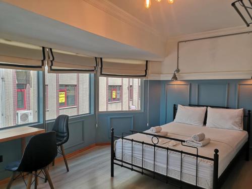 een slaapkamer met een bed, een bureau en een aantal ramen bij Panorama Suite in Istanbul