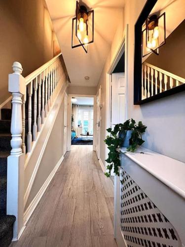 a hallway of a home with a staircase with a plant at Damson Drive- Boutique Home in Oldbury