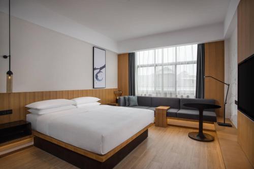 a hotel room with a bed and a couch at Fairfield by Marriott Jingdezhen in Jingdezhen