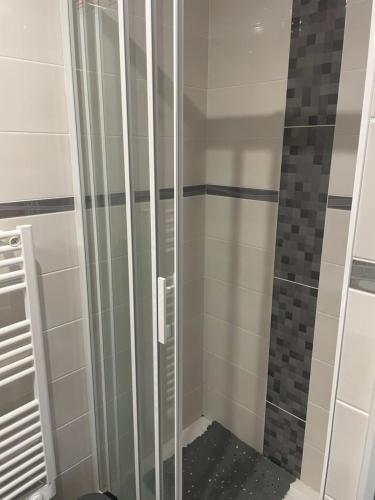 La salle de bains est pourvue d'une douche avec des portes en verre. dans l'établissement Laugann's Home, à Cabourg