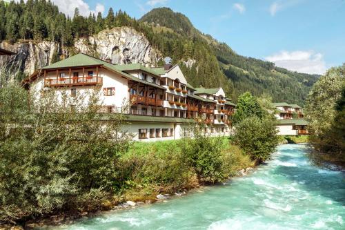 a hotel in the mountains next to a river at ROBINSON AMADÉ in Kleinarl