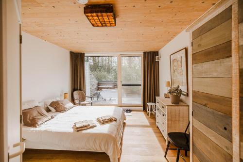 een slaapkamer met een bed en een houten muur bij ScraB&Ble Ecologische gastenkamers in Bornem