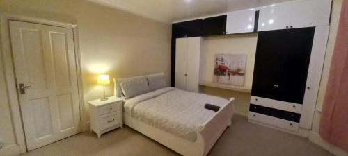 a bedroom with a bed and a dresser and a door at Bostall Lane Family Home in Abbey Wood