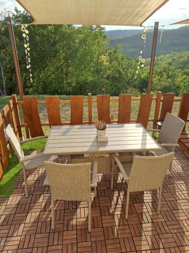 einen Holztisch und Stühle auf einer Terrasse in der Unterkunft Remete Vendégház in Szekszárd