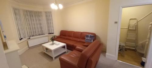 a living room with a couch and a table at Bostall Lane Family Home in Abbey Wood