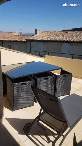 a table and two trash cans on a roof at le Rempart in Grignan